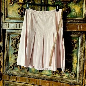 Pleated pale pink skirt with contrasting tan ribbon tie.